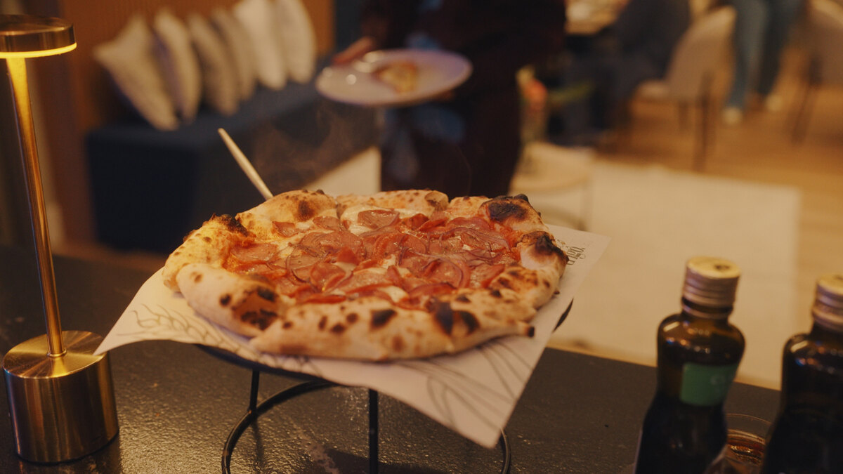 Pizza artesanal da Trigô servida sobre a mesa em luz quente